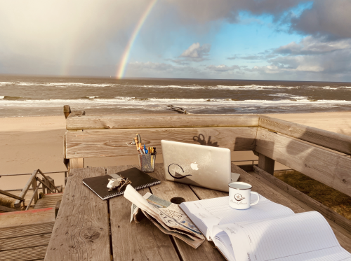 Beachhouse Westerland Sylt Terrasse mit Macbook von Jan Schafe vor einem Regenbogen