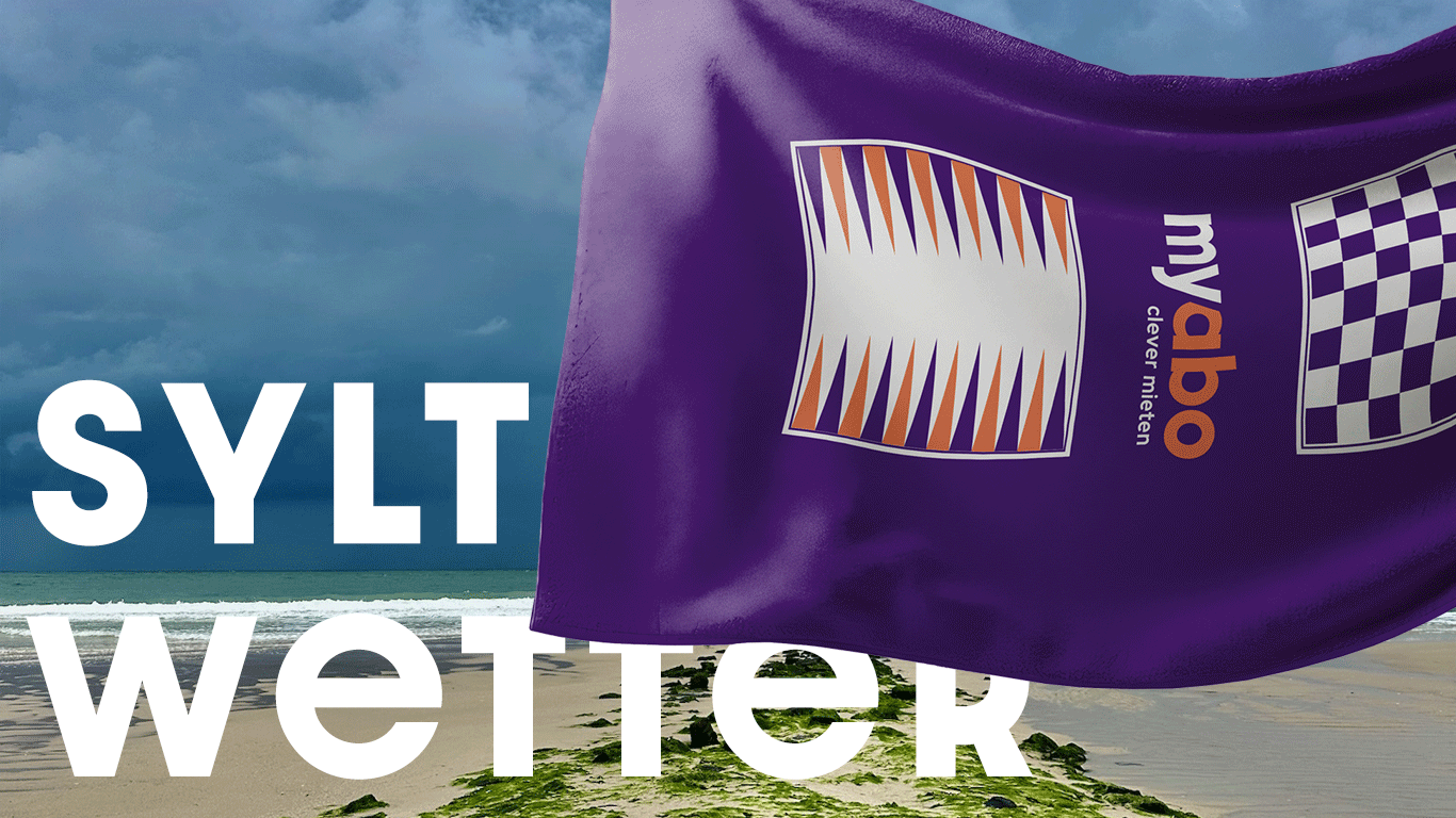 Ein Handtuch von myabo weht im Wind am Strand von Sylt, mit Sand und Meer im Hintergrund.